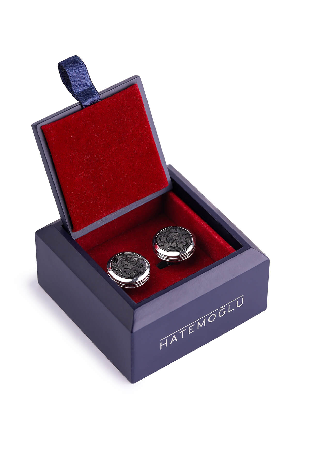 Silver-toned cufflinks with intricate black engraved patterns, presented in a navy blue velvet-lined box.