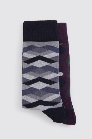 Three pairs of socks, featuring a gray and black chevron pattern on one pair and dark purple with white polka dots on another.