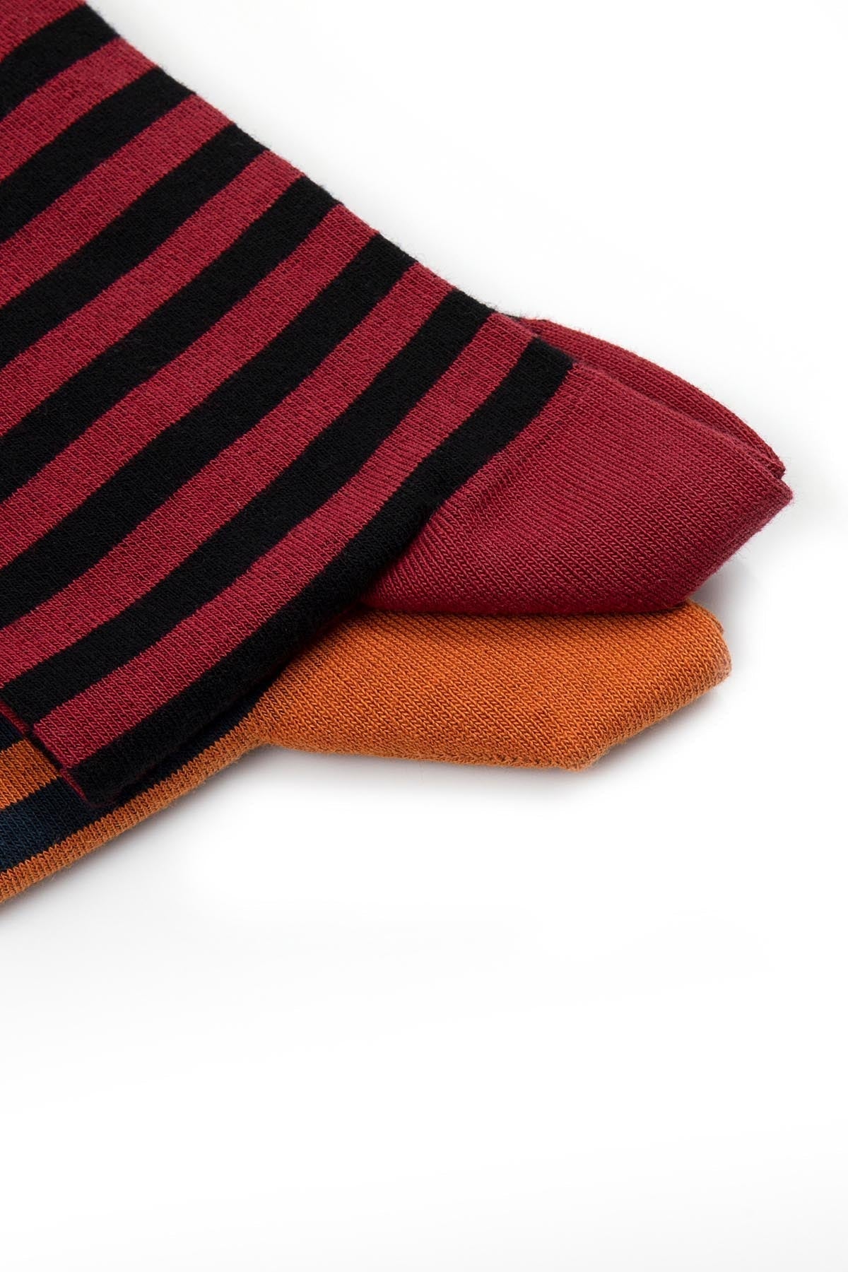 A pair of maroon and black striped socks with a ribbed texture, featuring an orange accent sock beneath.