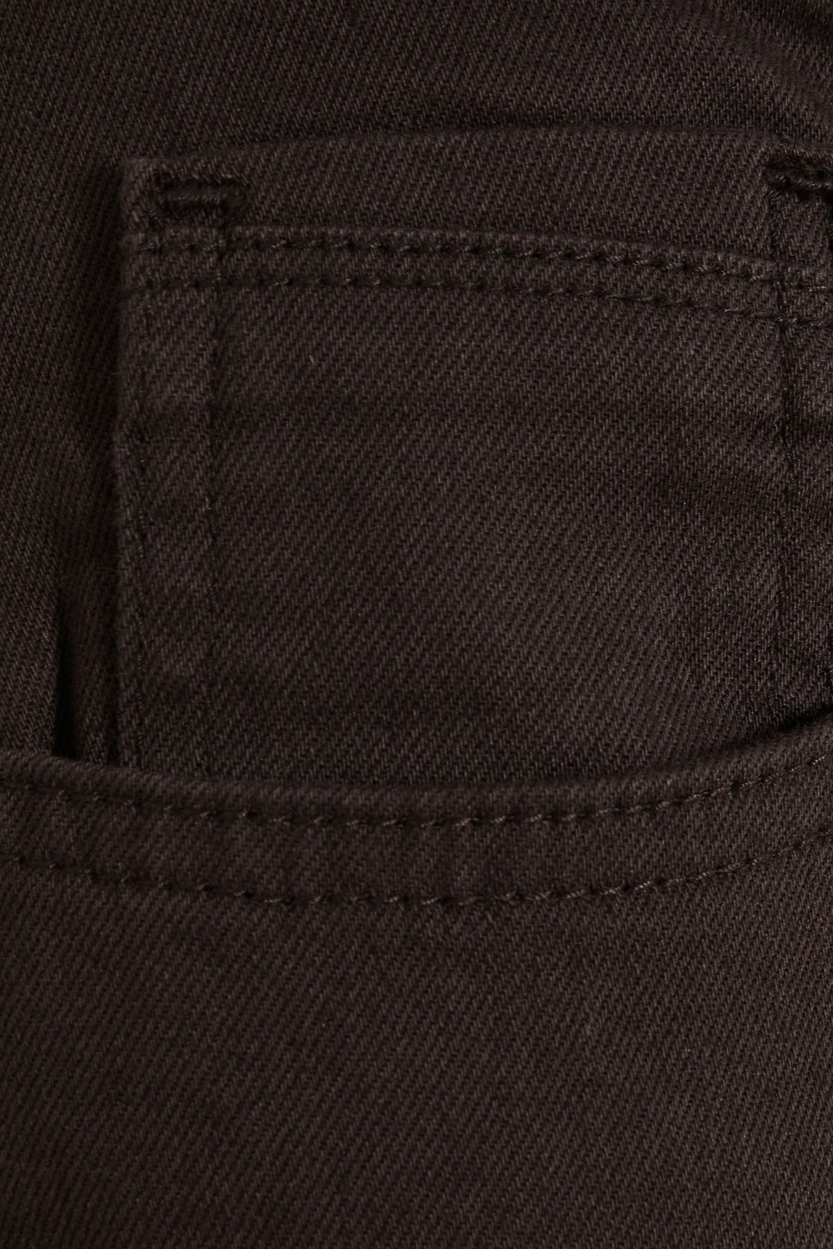 Dark brown denim pocket with visible stitching and a subtle diagonal weave texture.
