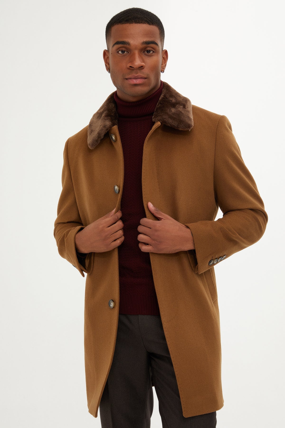 A tan wool coat with a plush brown fur collar and matching buttons.