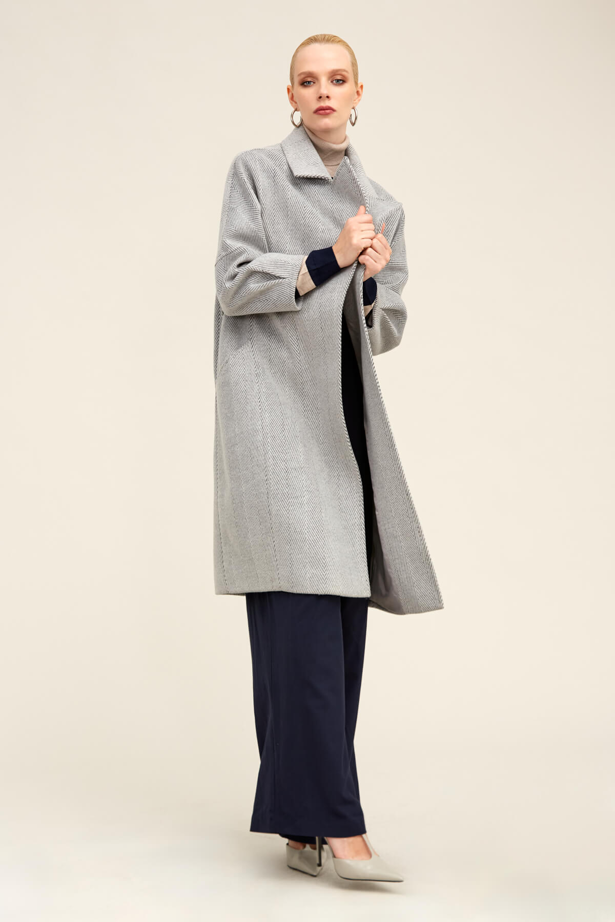 A stylish gray herringbone wool coat with a classic collar and long sleeves.