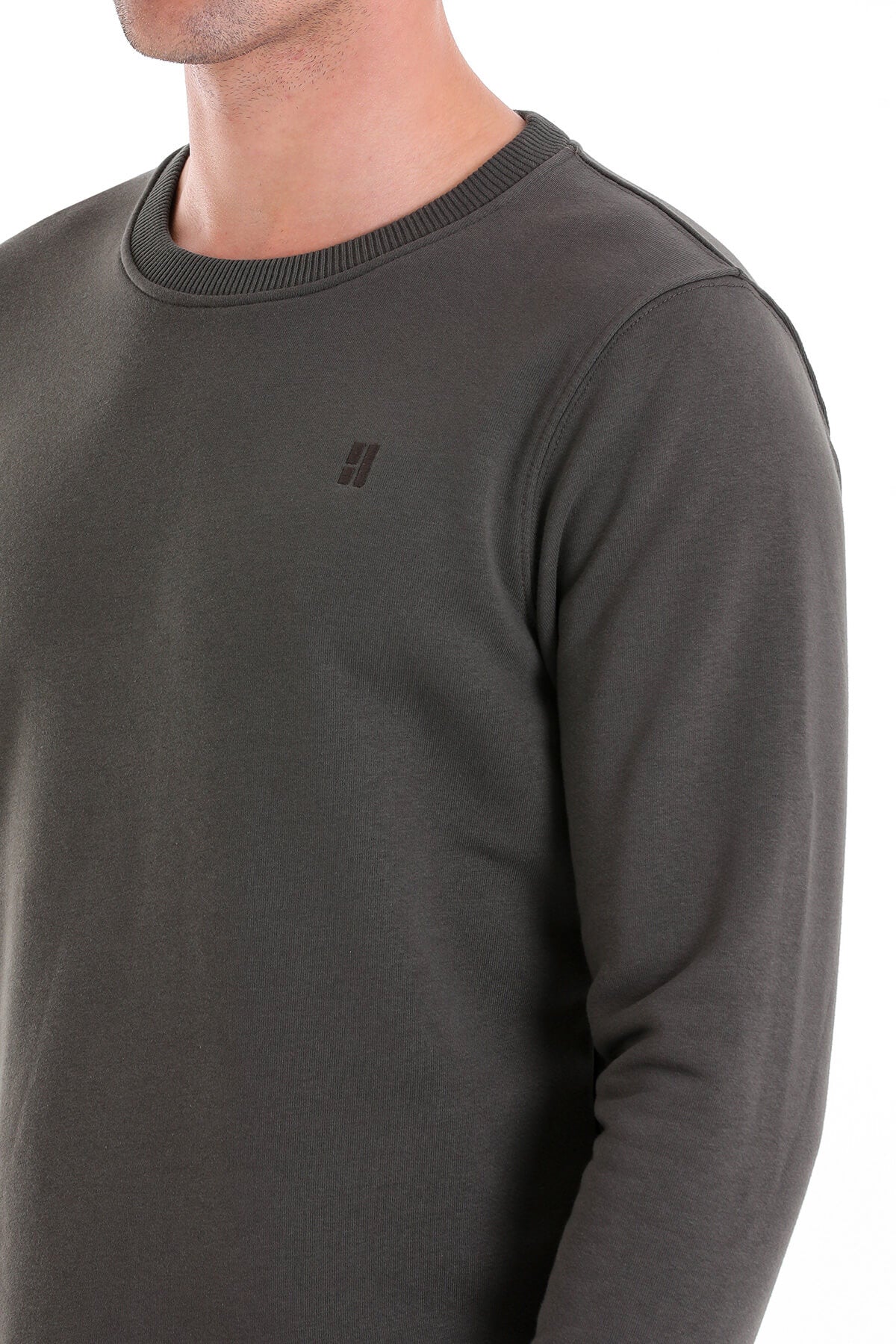 Dark olive green long-sleeved crew neck sweatshirt with a subtle ribbed collar and small black logo on the chest.