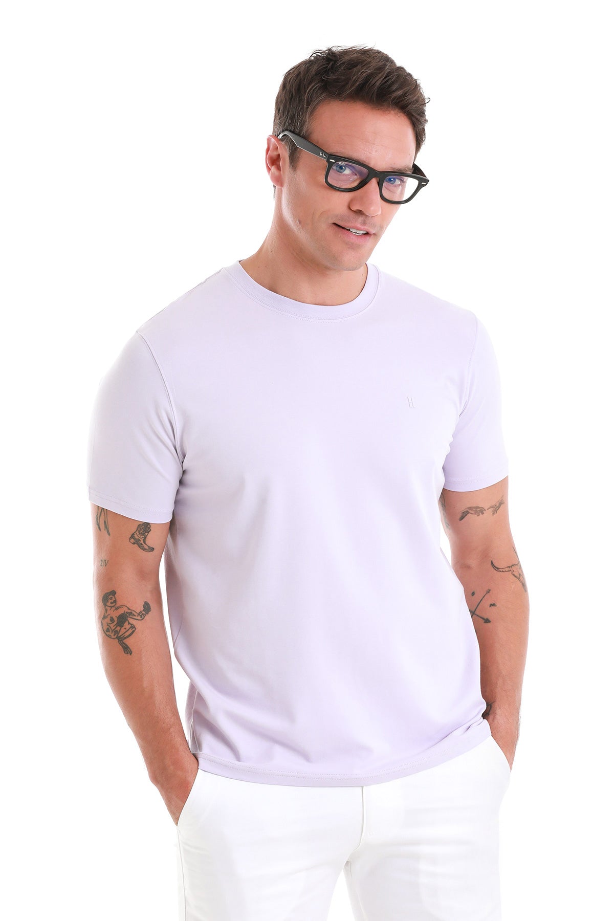 A man wearing a light lavender, short-sleeved crew neck t-shirt.