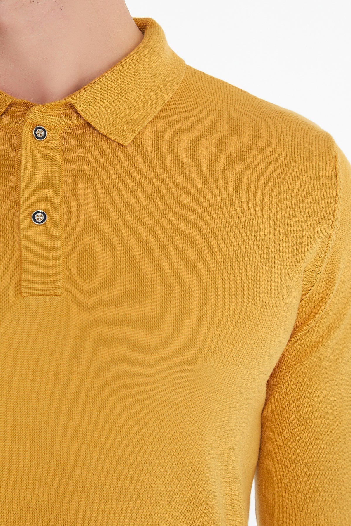A mustard-yellow, long-sleeved polo shirt with a ribbed knit texture and dark button closures.
