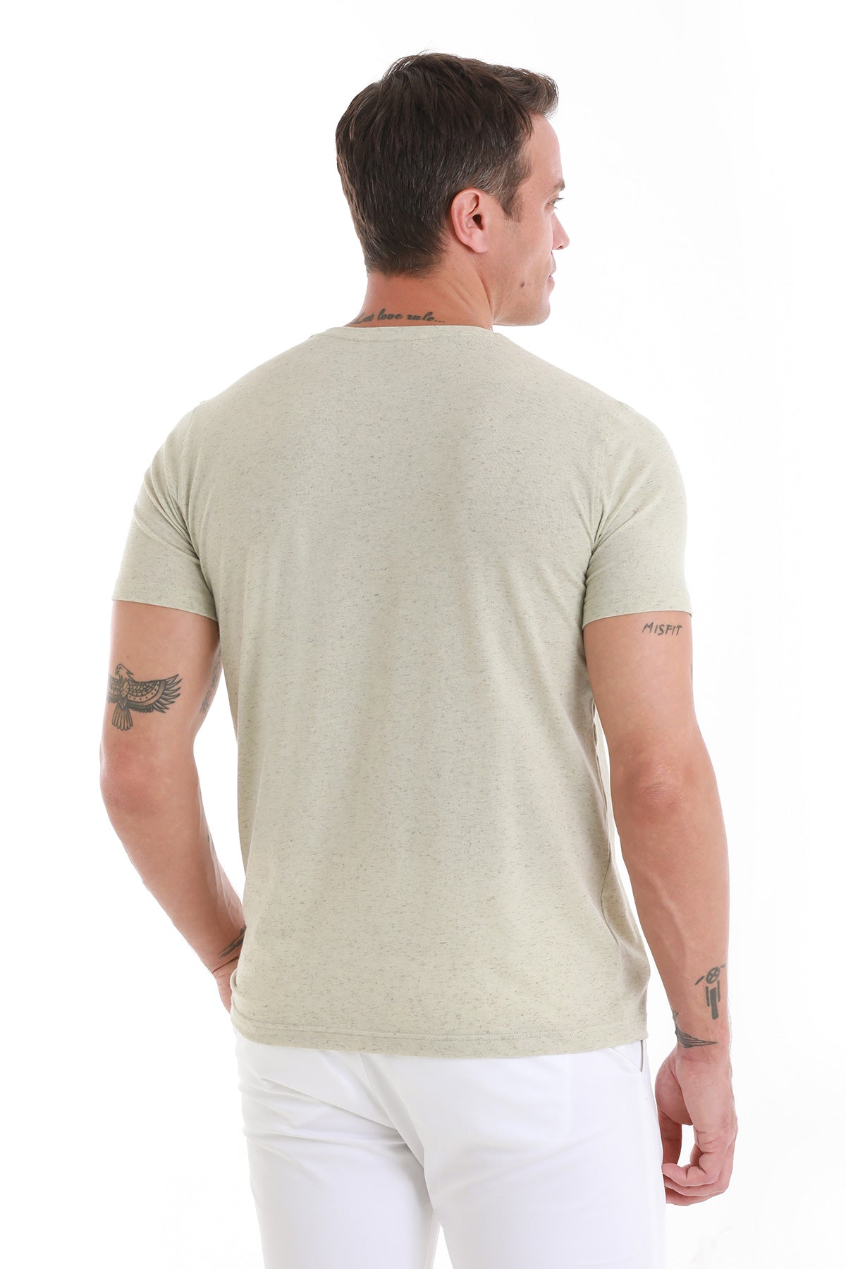 A man wearing a light olive green, short-sleeved crew neck t-shirt.