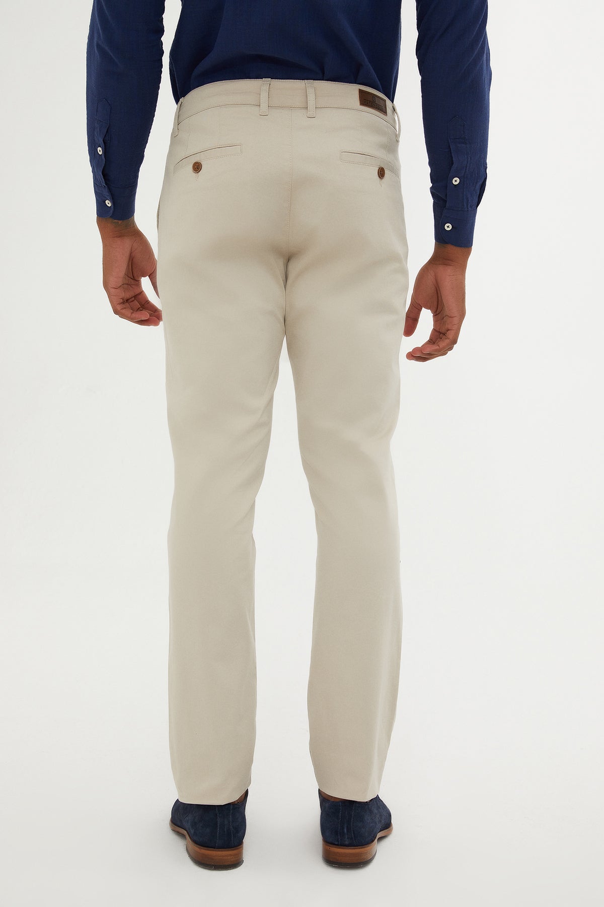 Beige chino trousers with brown button accents and a subtle woven texture.