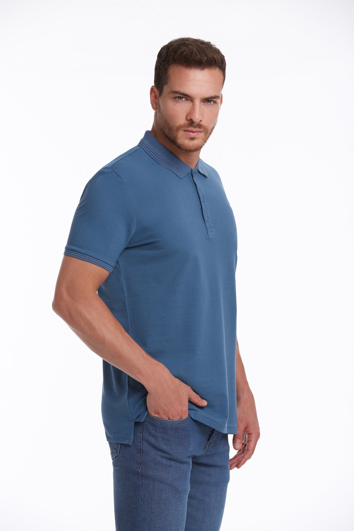 A man wearing a solid blue short-sleeved polo shirt with a classic collar and ribbed cuffs.