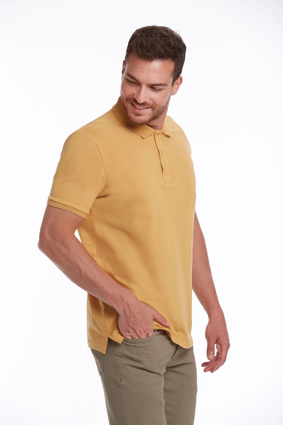 A man wearing a mustard-yellow short-sleeved polo shirt with a classic collar and ribbed cuffs.