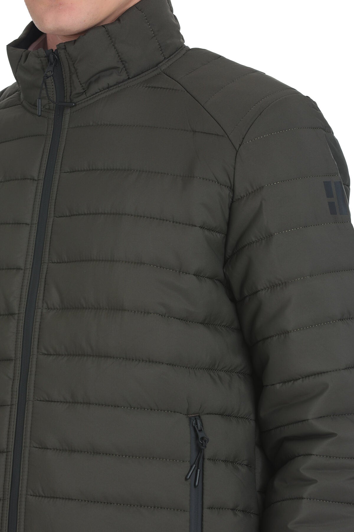 Dark olive green quilted puffer jacket with black zipper accents and a subtle brand logo patch on the sleeve.