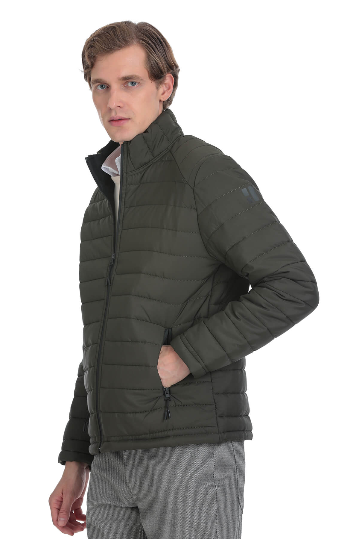 Dark olive green quilted puffer jacket with a high collar and zippered pockets.