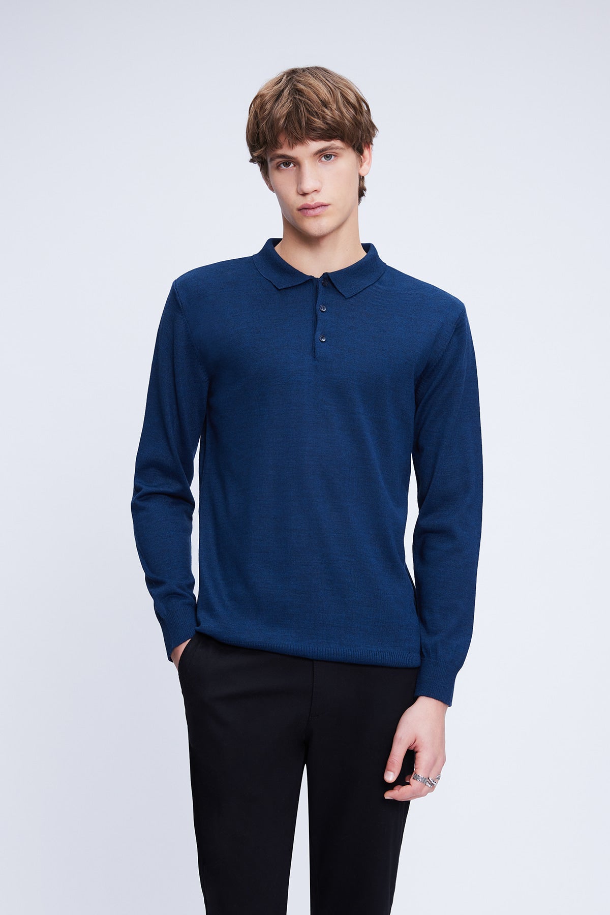 A navy blue long-sleeved knit polo shirt with a classic collar and three-button placket.