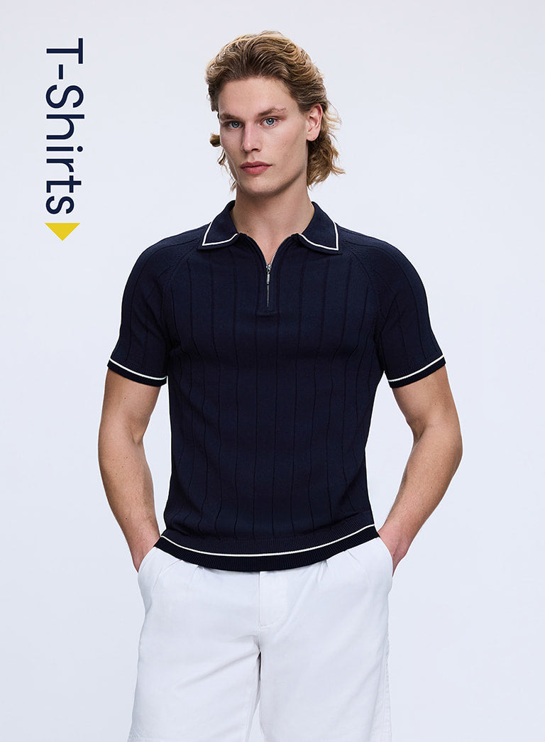 Man wearing a navy polo shirt with white trim on a light gray background