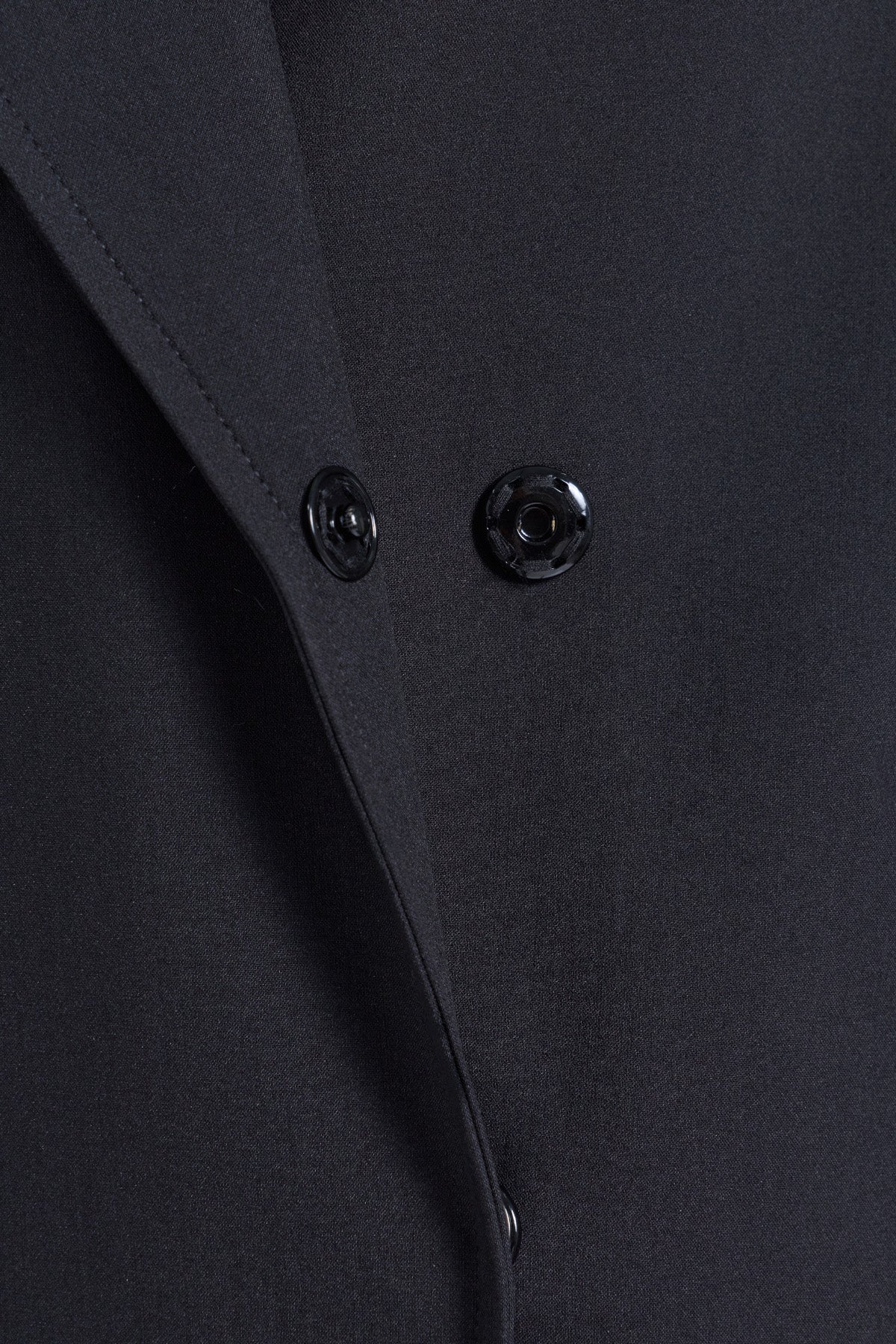 Black satin fabric with two glossy black buttons on sayki woman dynamic fit cachet black oversized coat