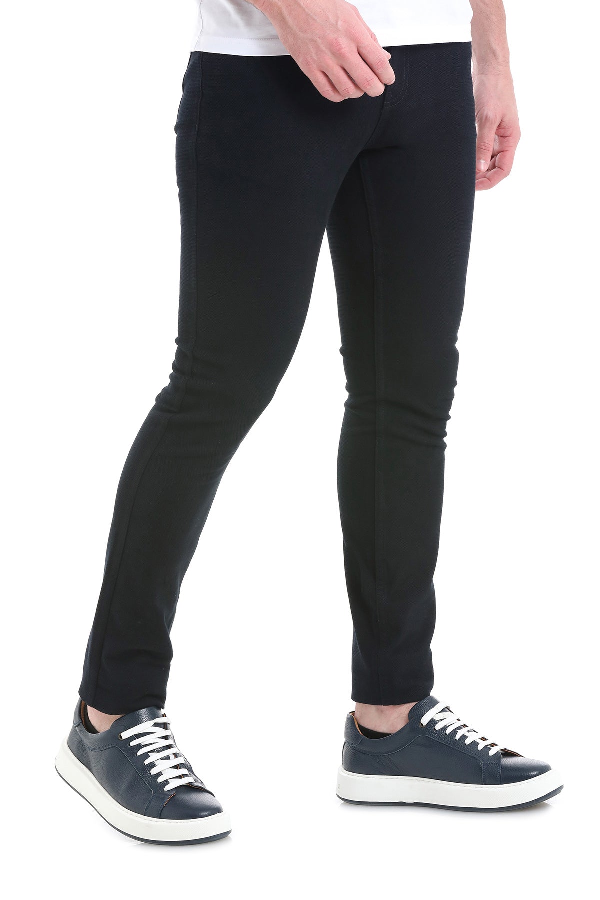 Black slim-fit trousers made of stretchy fabric, paired with dark blue platform sneakers.