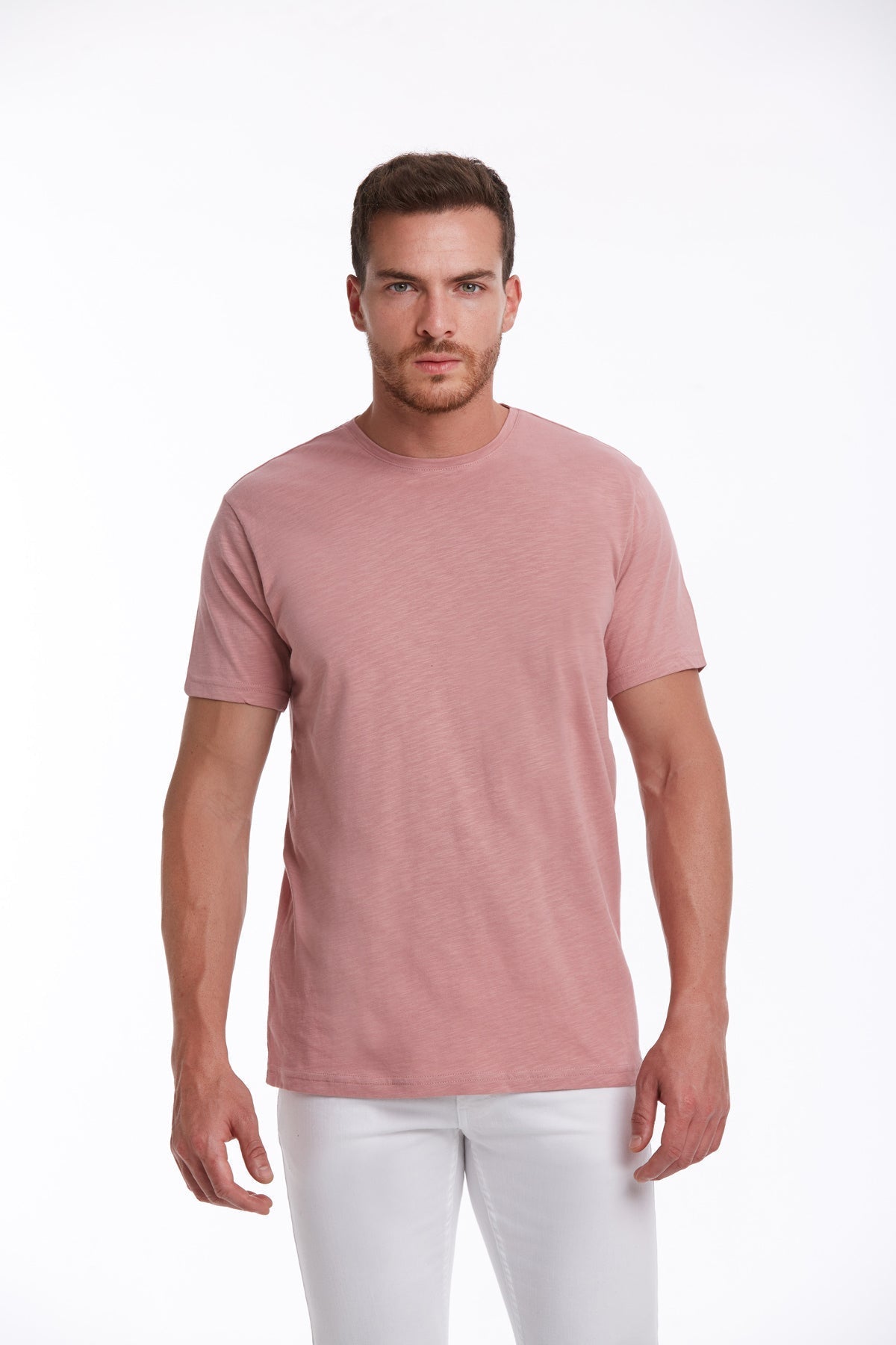 A soft blush pink, short-sleeved crew neck t-shirt made of smooth cotton fabric.