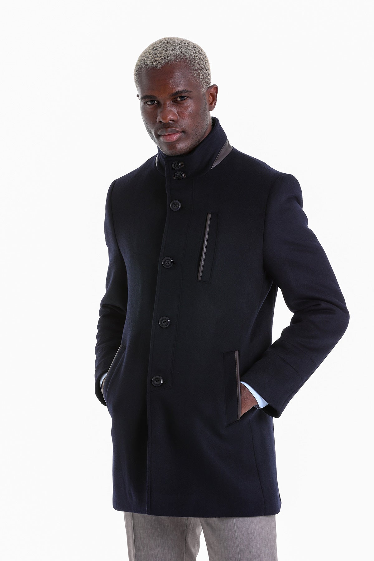 Black woolen coat with a high collar and dark buttons.
