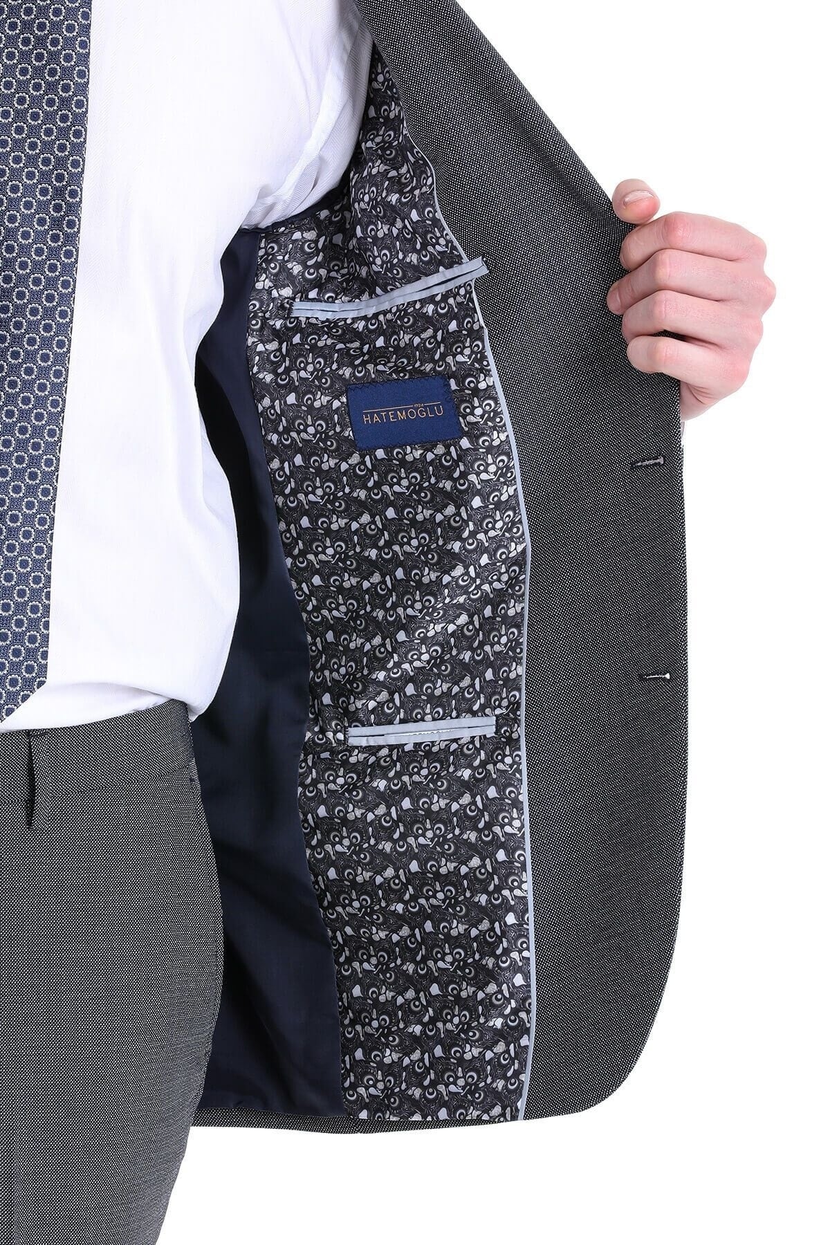 Dark gray textured wool blazer with a navy blue interior lining and an intricate white floral pattern on the inner pocket flap.