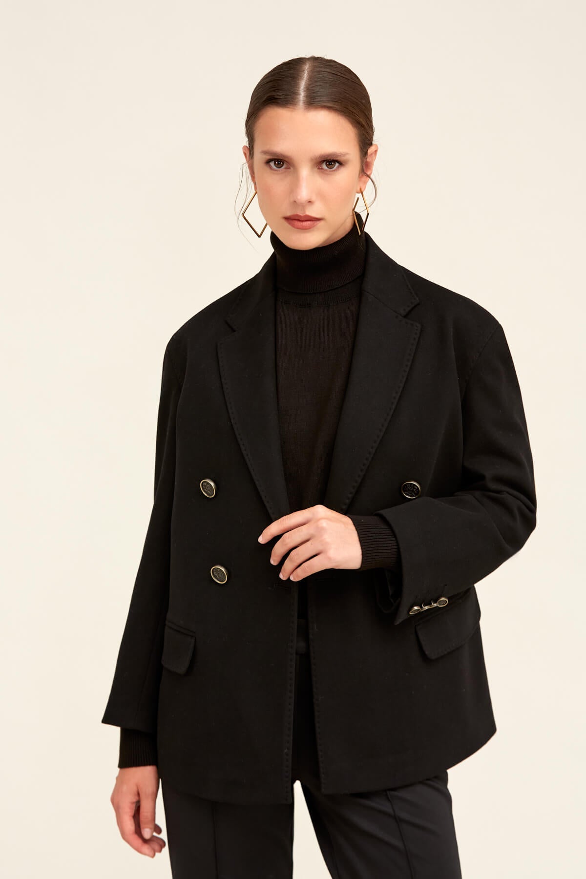 Black double-breasted blazer with silver-toned buttons and structured shoulders.