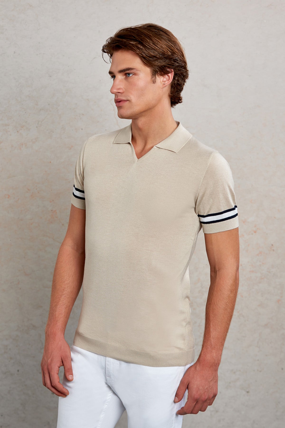 Beige short-sleeved polo shirt with black and white striped cuffs.