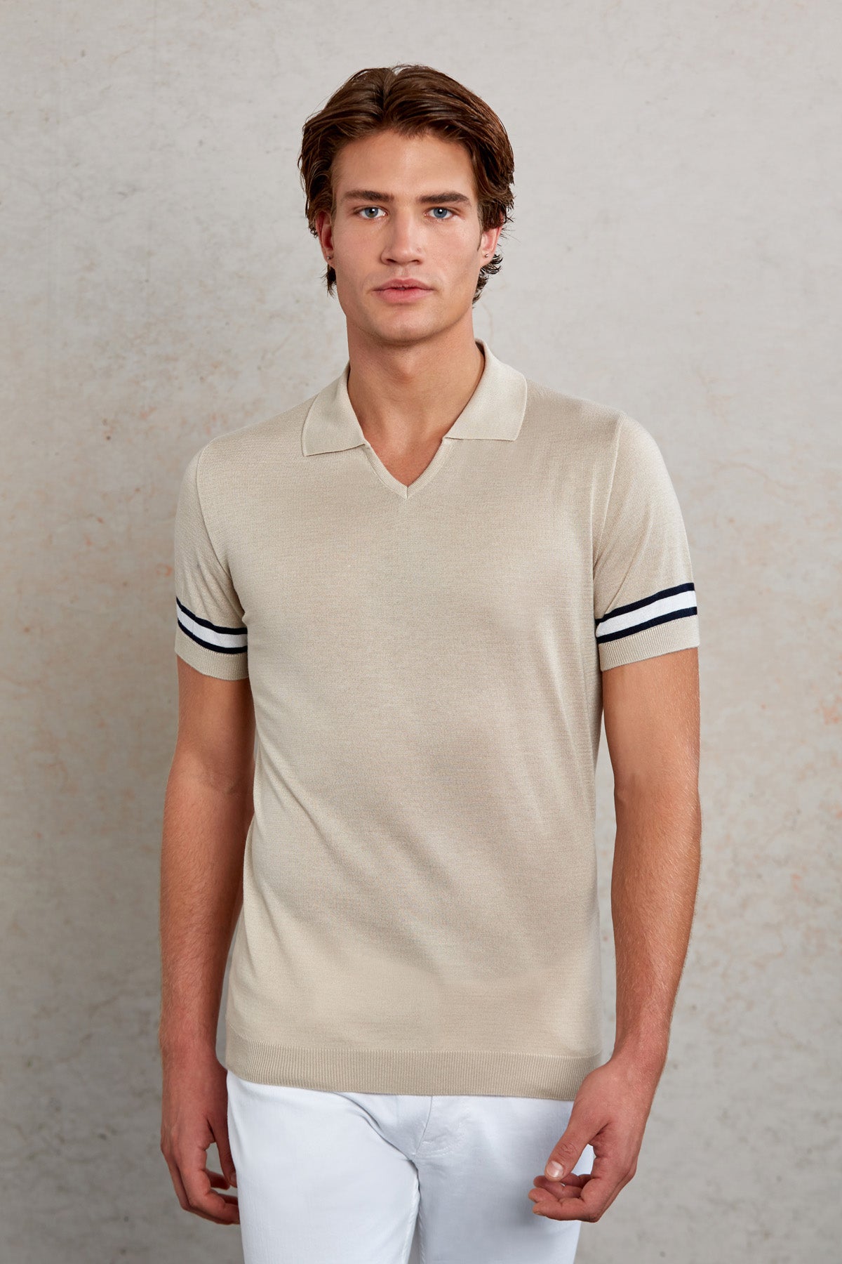 Beige short-sleeved polo shirt with black and white striped cuffs.