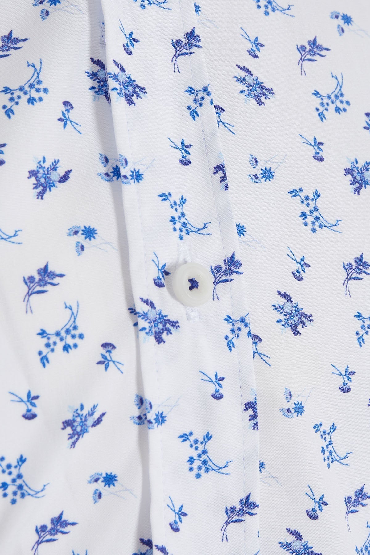 White button-down shirt with delicate blue floral pattern.