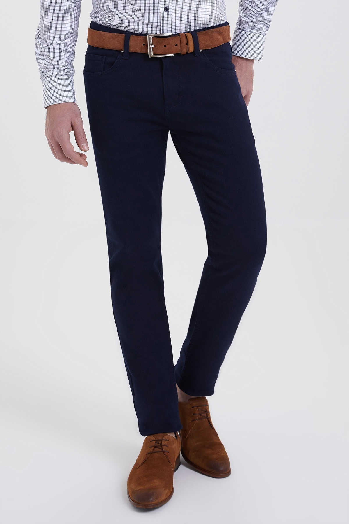 Navy blue slim-fit chinos with a brown leather belt and silver buckle