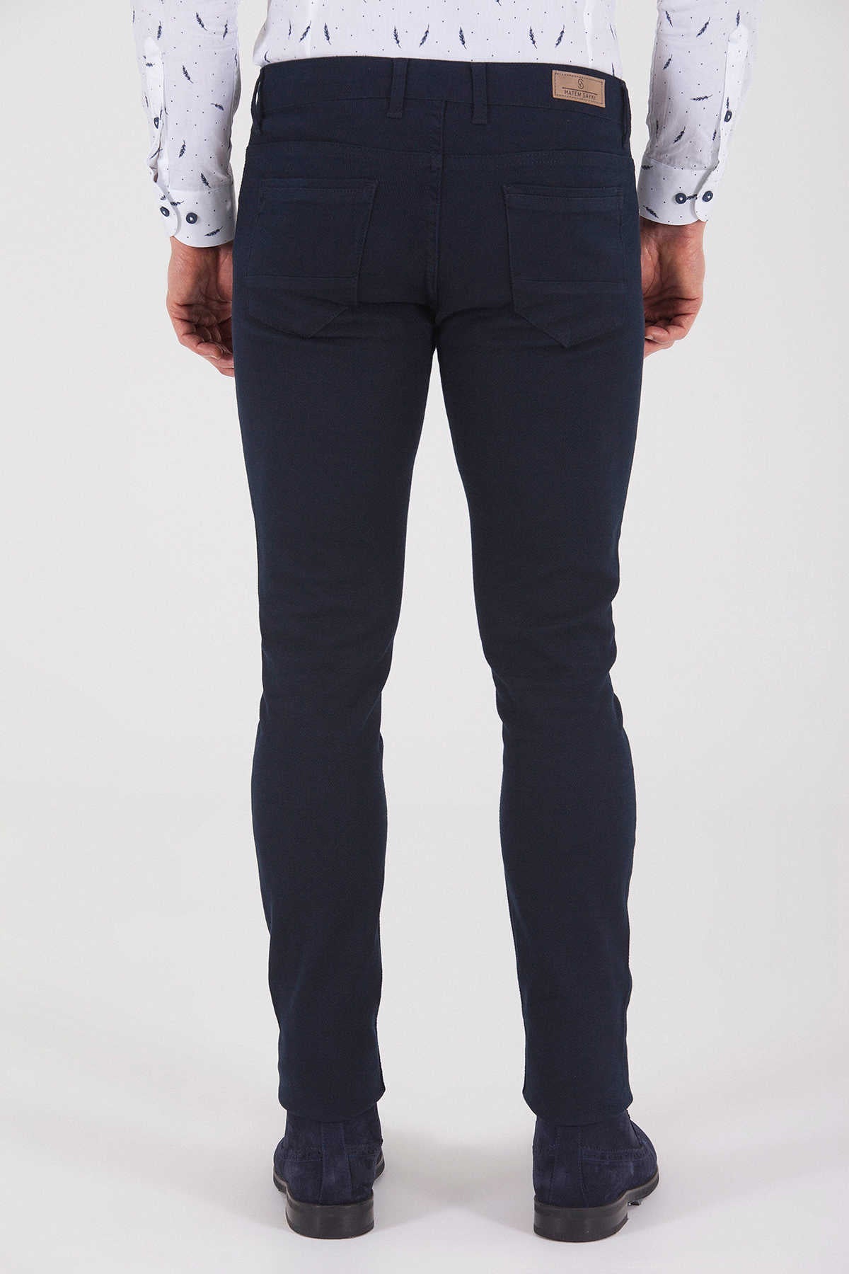 Dark navy blue slim-fit jeans with a subtle texture and a brown leather brand patch on the waistband.