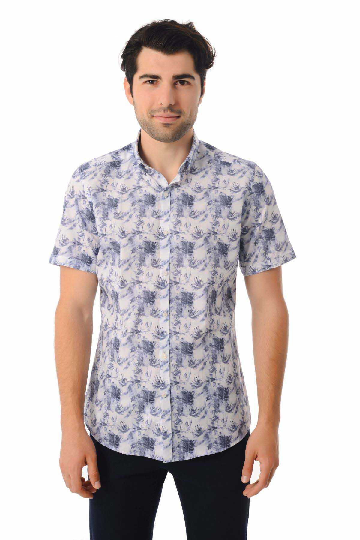 A man wearing a short-sleeved button-up shirt with a white base and blue botanical print.