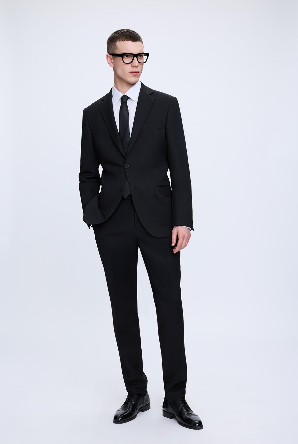 Slim fit notch lapel black smart casual suit with sleek modern cut and matching black dress shoes