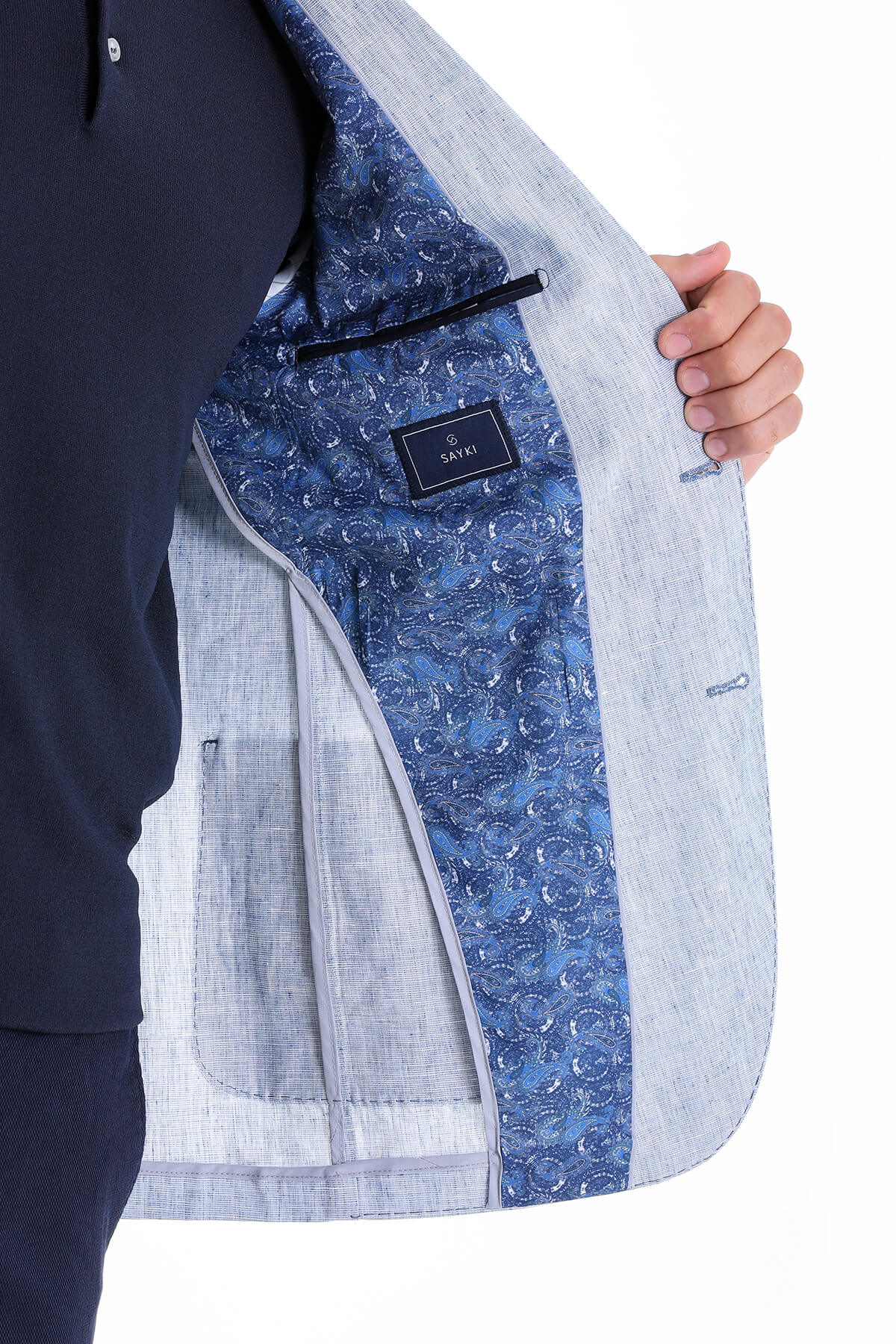 Light gray textured blazer with a navy blue patterned lining featuring circular motifs.