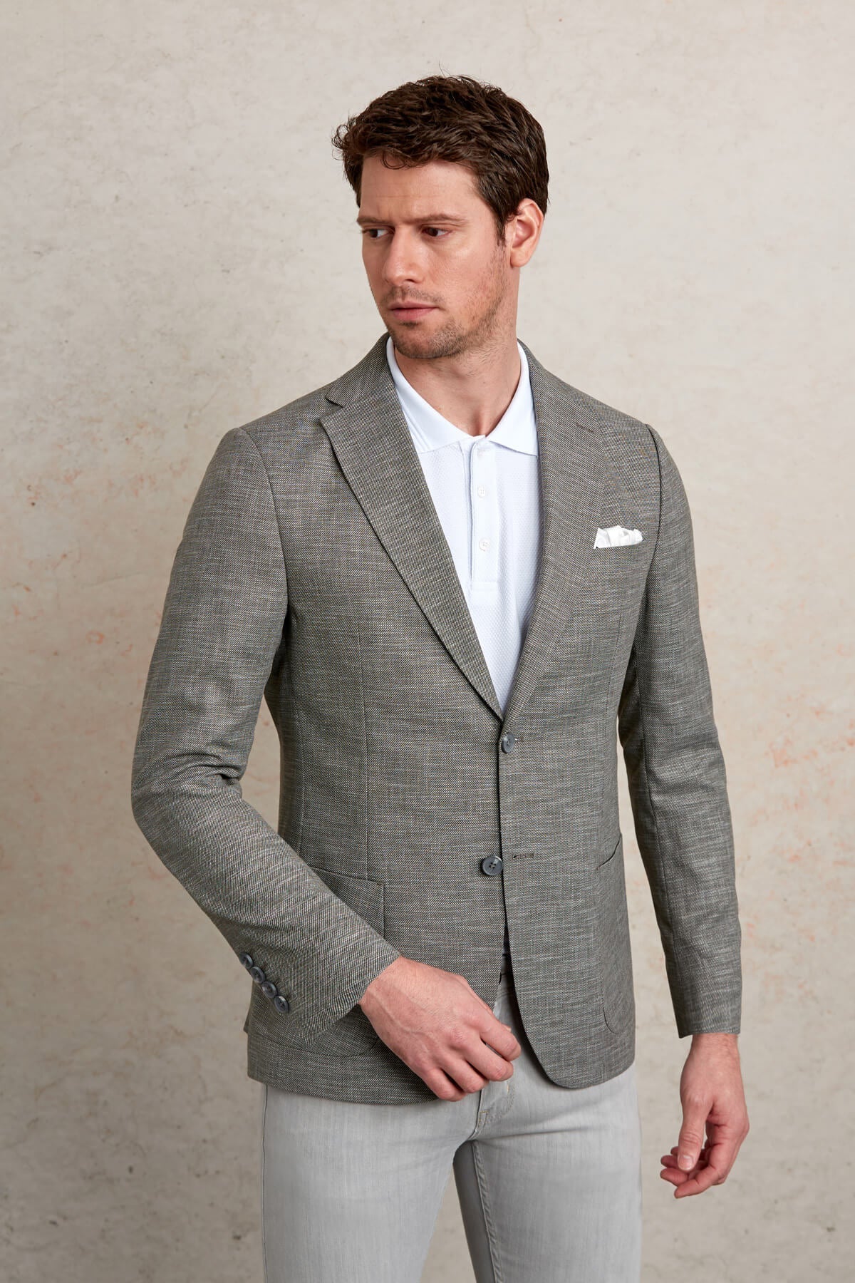 Gray textured blazer with subtle pattern and three-button closure.