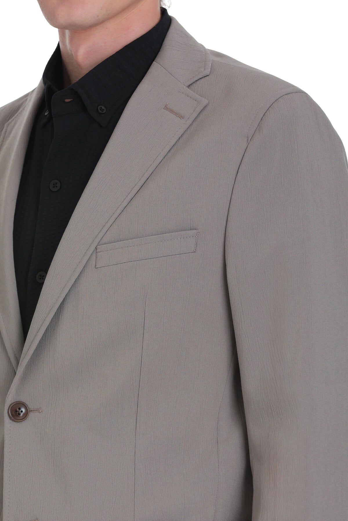 A sleek, light gray men’s blazer with a subtle textured weave and a single button closure.