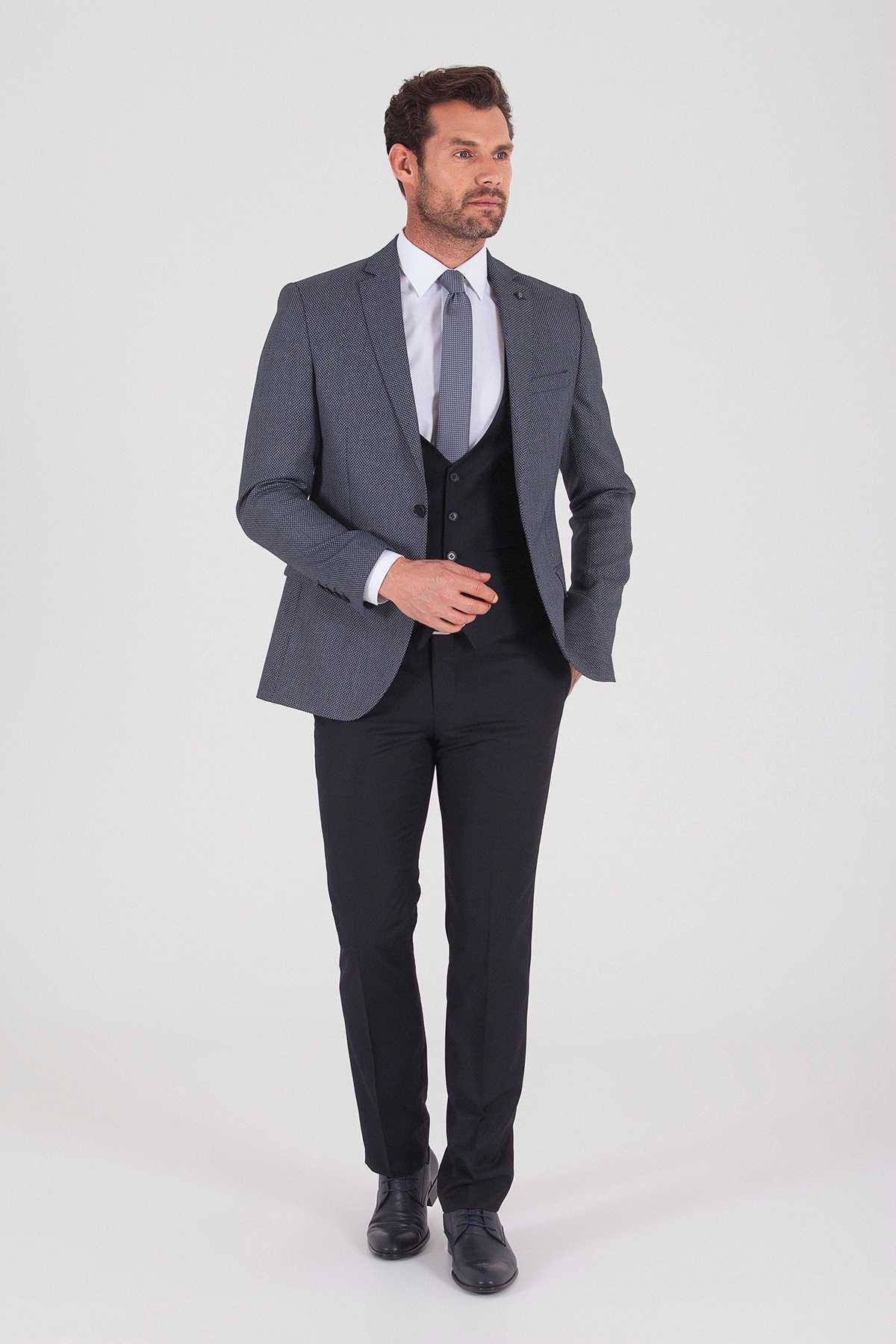 Men’s charcoal gray textured three-piece suit with matching vest and trousers.