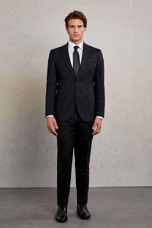 Black tailored suit with a subtle textured pattern and matching black tie.