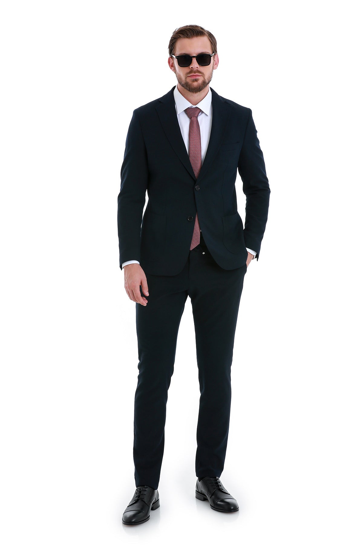 Black tailored suit with a subtle texture, paired with a patterned tie and matching trousers.