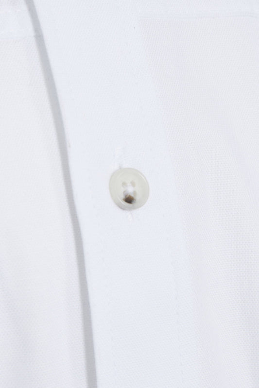 A small, round, silver button with a subtle sheen and two tiny holes for threading.