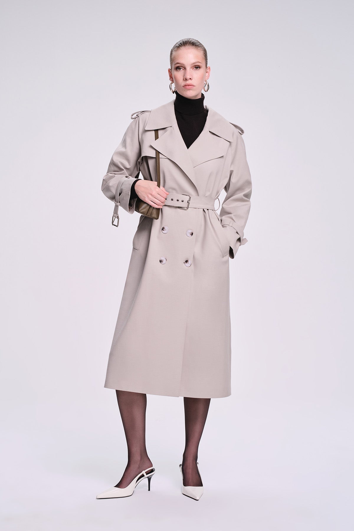 Beige trench coat with double-breasted front, belted waist, and structured shoulders.