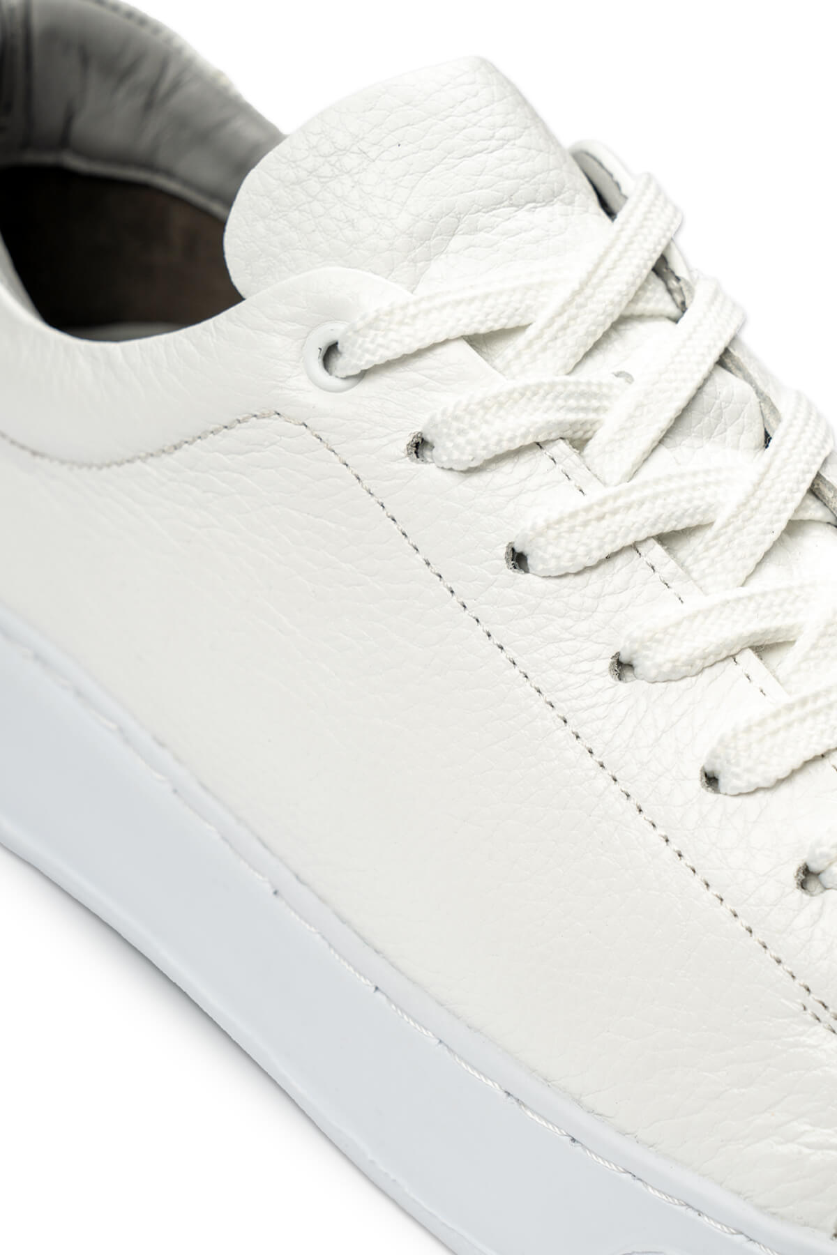 White leather low-top sneaker with matching laces and a clean, minimalist design.