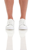 White leather low-top sneakers with clean, minimalist design.