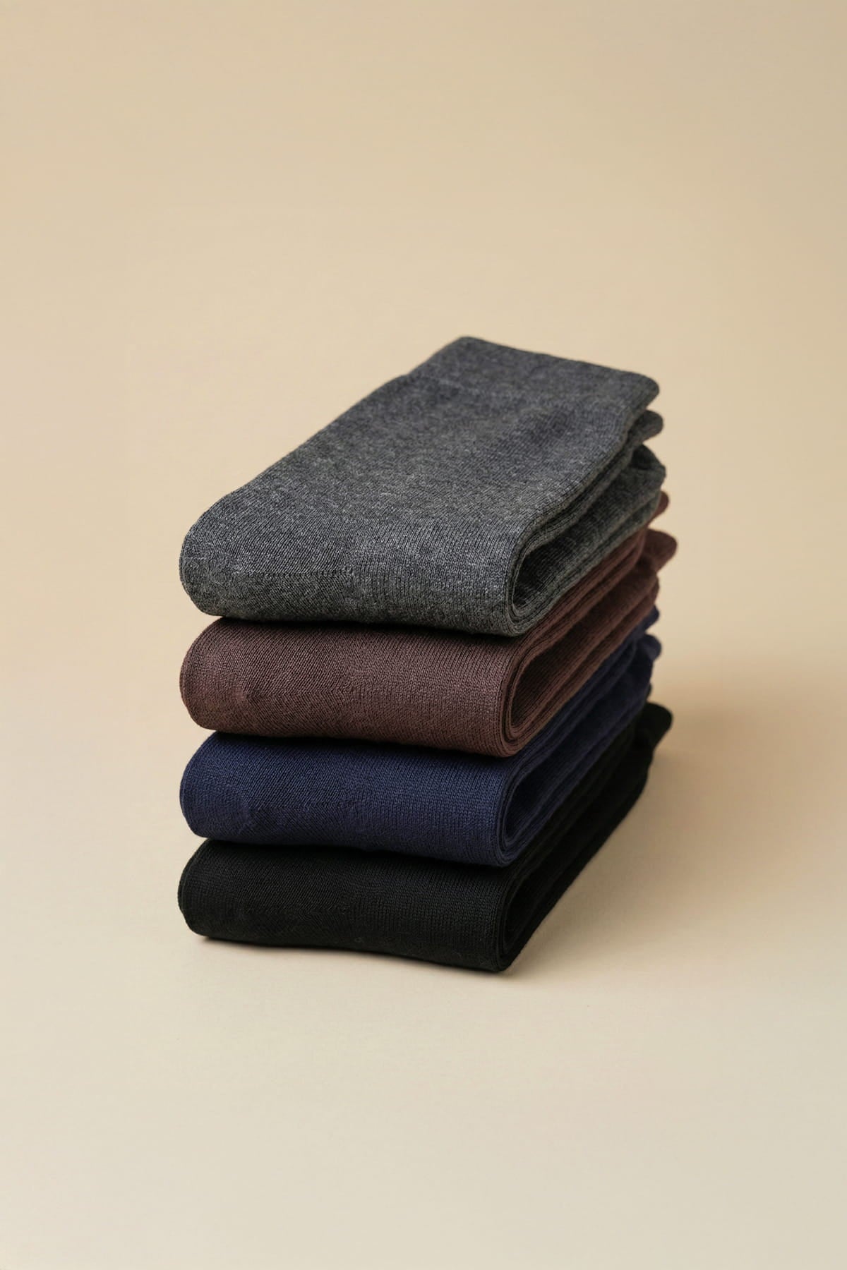 Stack of four neatly folded dark gray brown navy blue and black socket bamboo dress socks in a 4-pack socks set