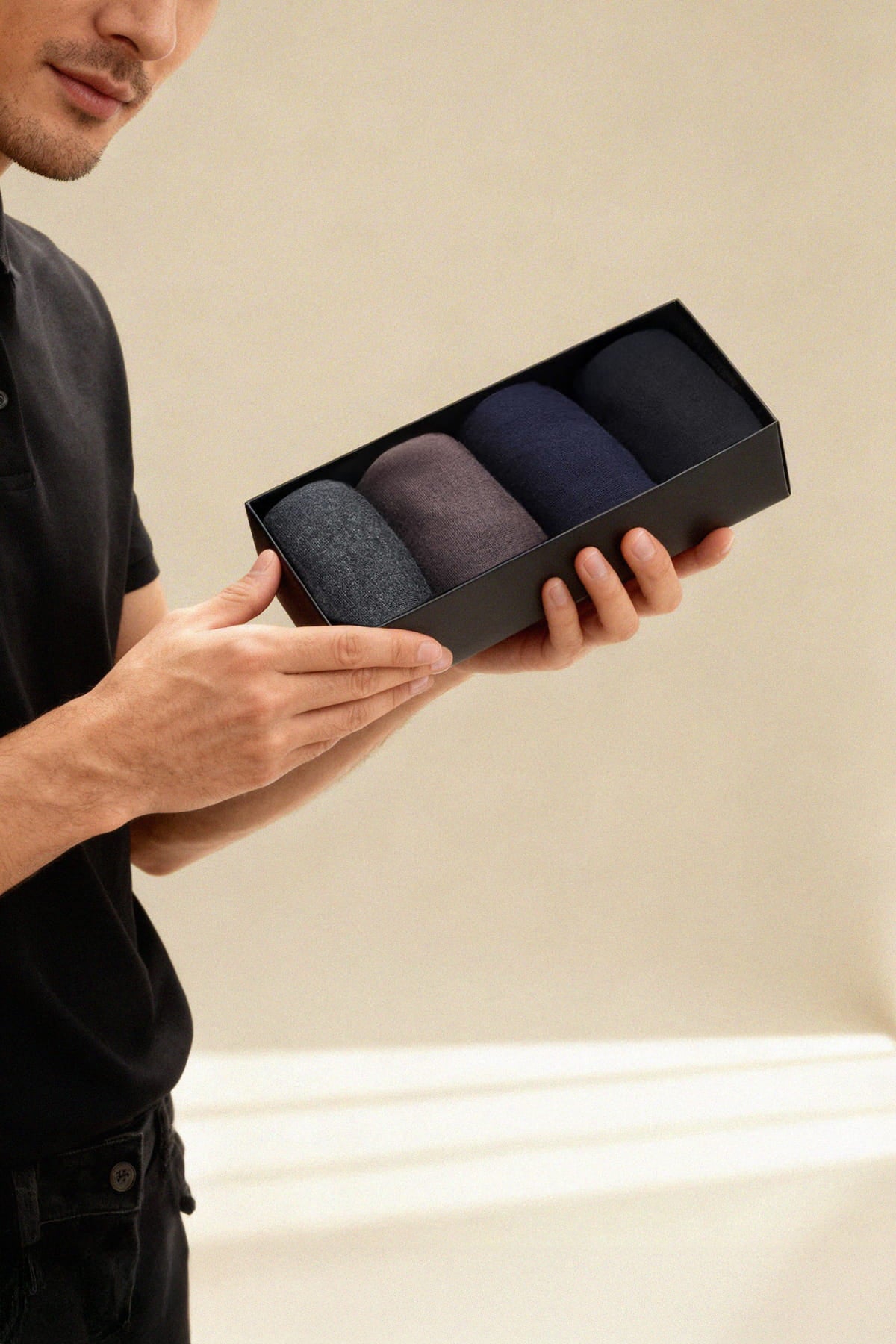 Black rectangular gift box with four neatly folded navy gray and charcoal bamboo dress socks in a 4-pack socket bamboo dress socks set