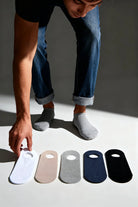 A row of five minimalist bamboo no show socks in white beige gray navy blue and black in a 5 pack