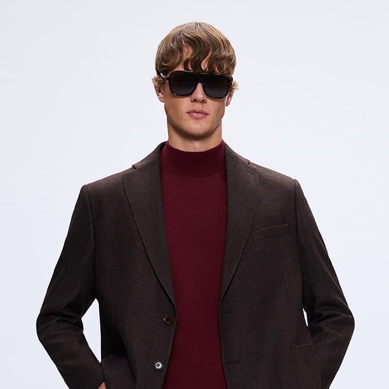 Man wearing dark blazer with burgundy knit and sunglasses, bold modern gift style