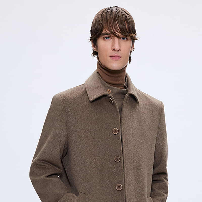 Man wearing brown wool coat over turtleneck, outerwear gift category