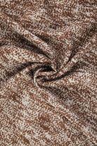 Brown and cream speckled fabric with a soft, flowing texture.