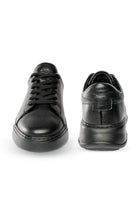 Black leather sneakers with a textured surface and chunky soles.
