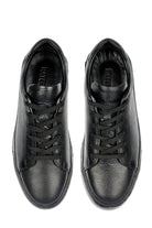 Black leather sneakers with a textured surface and matching laces.