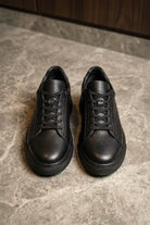 Black leather lace up sneakers featuring textured pebbled leather and matching pebbled leather laces