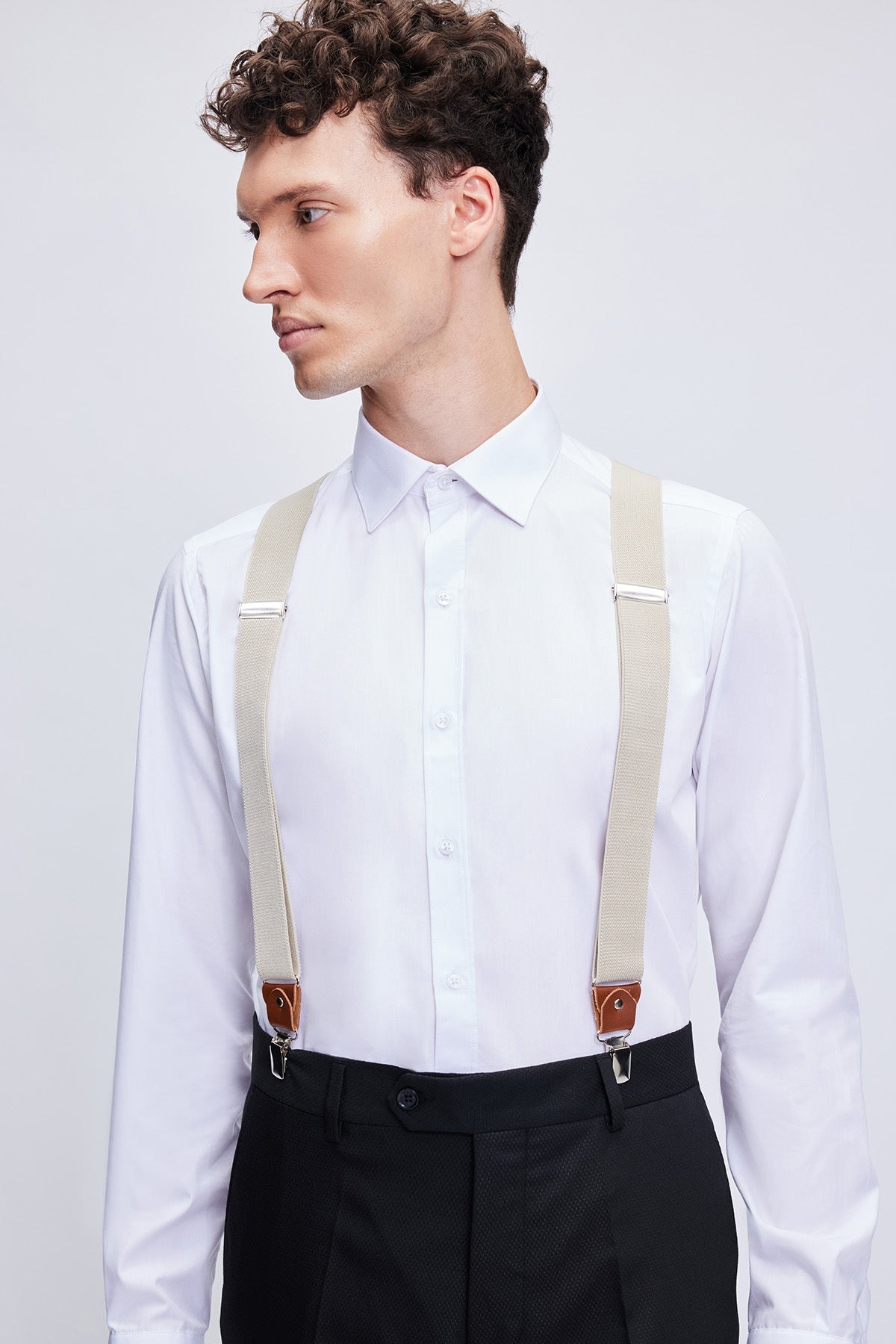 Beige fabric suspenders with brown leather trim clip adjusters showing stylish beige leather trim details